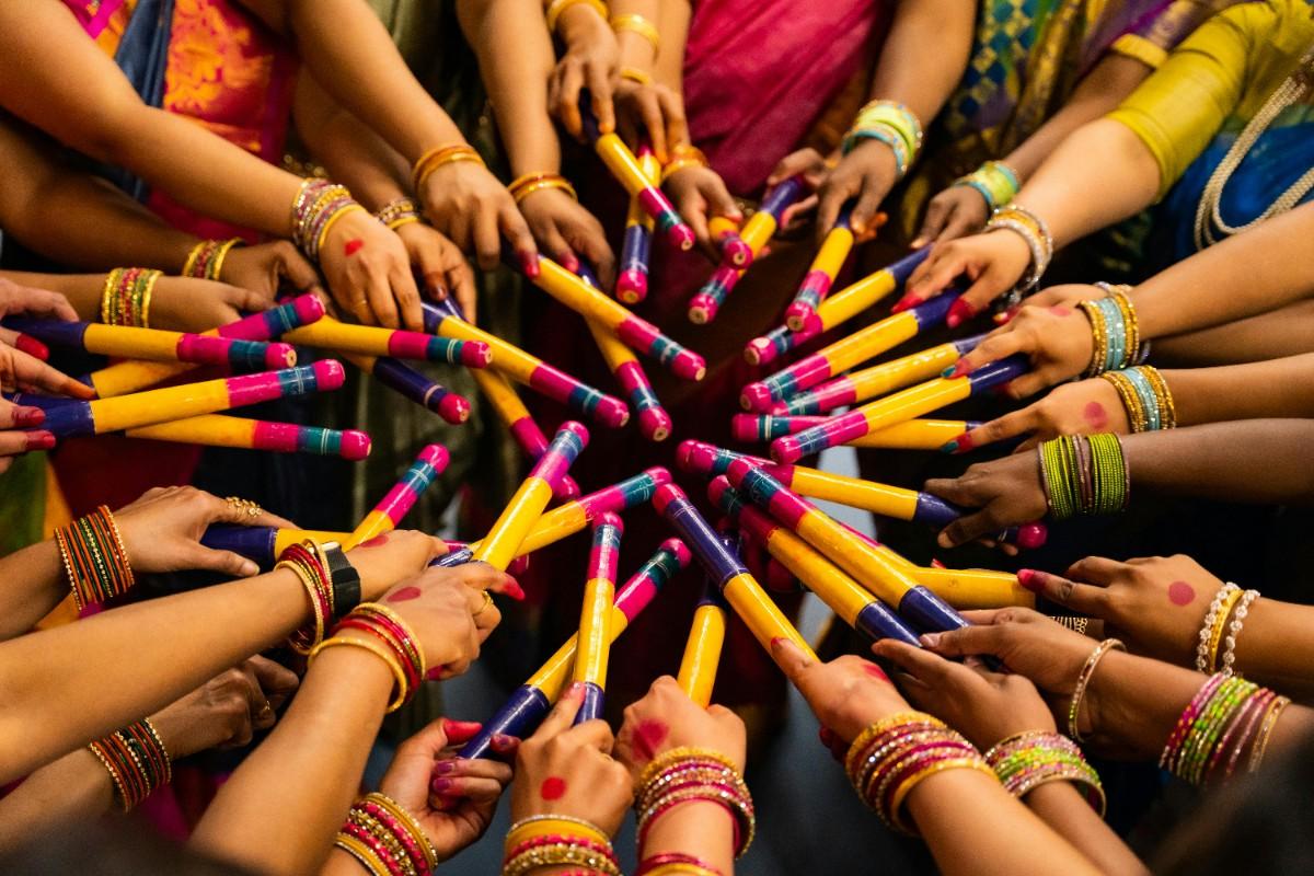 Women performing dandiya dance holding colorful sticks during Navratri