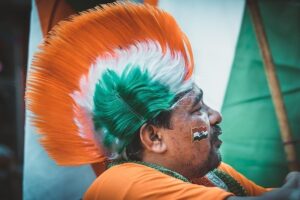 Patriotic Indian man with tricolor hair and face paint celebrating Republic Day of India with national enthusiasm